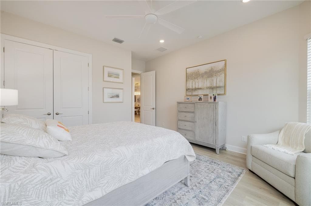 Bedroom with light wood-type flooring, recessed lighting, ceiling fan, and a closet
