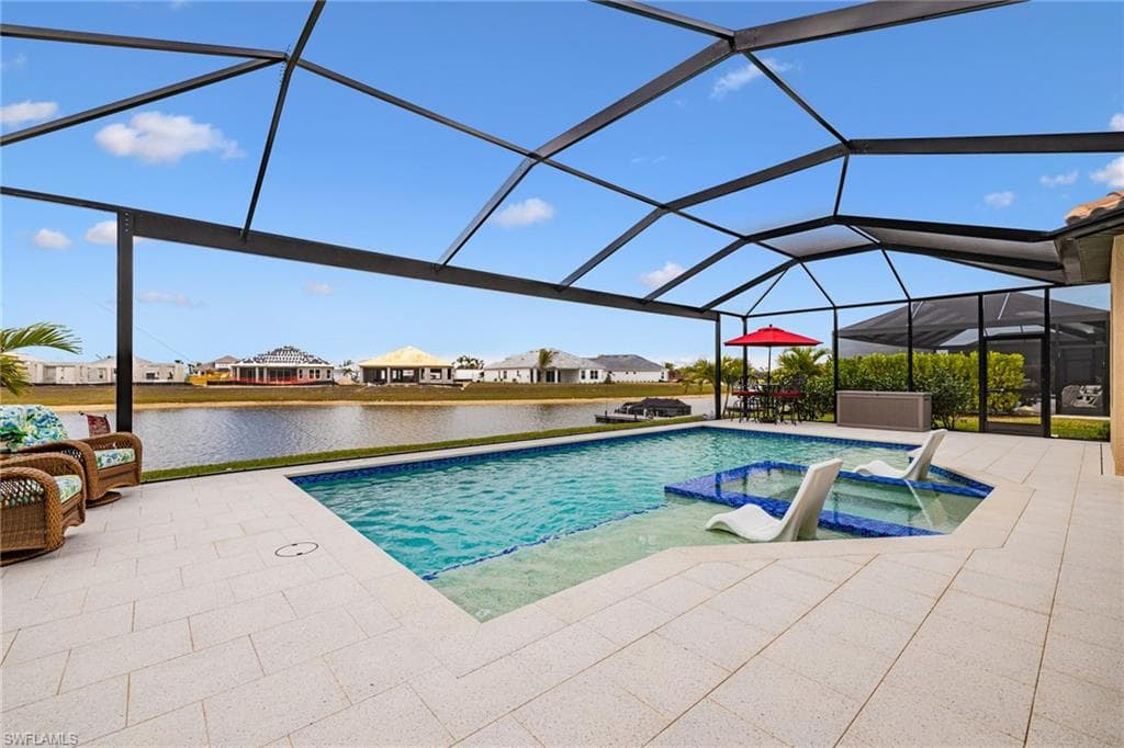 Integrated pool / hot tub featuring a sunroom, a residential view, a lanai, a patio area, and a water view