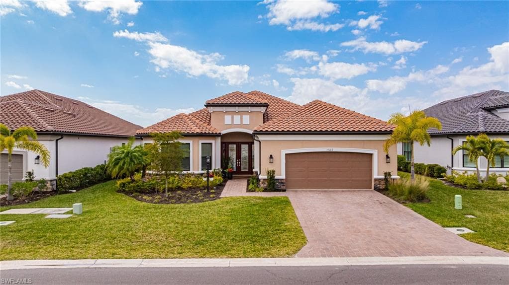 Mediterranean / spanish-style home featuring stucco siding, an attached garage, stone siding, french doors, and a front yard
