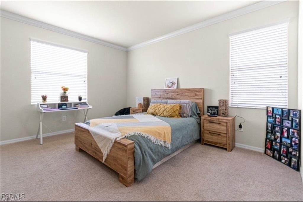 Bedroom with light carpet and crown molding
