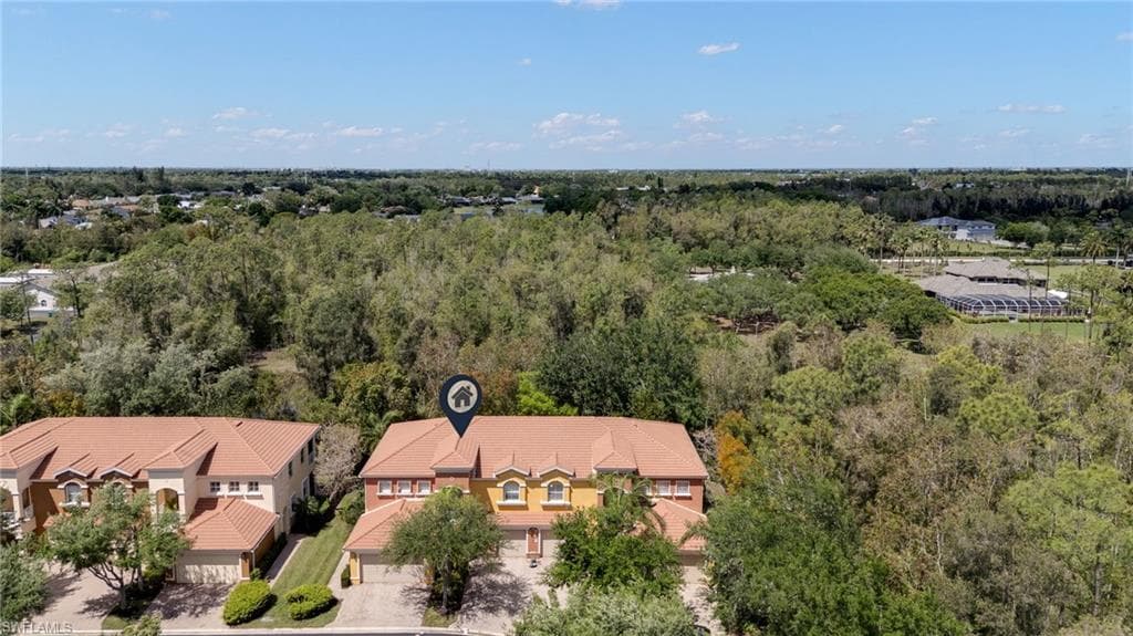 Aerial view of residential area featuring a heavily wooded area