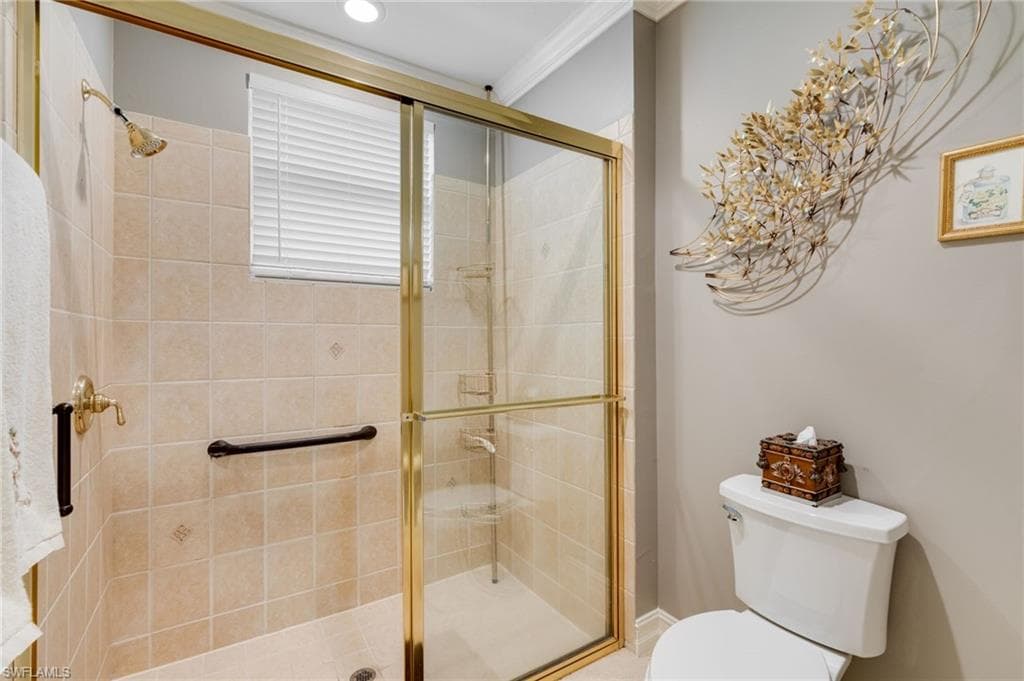 Full bath featuring a stall shower and ornamental molding