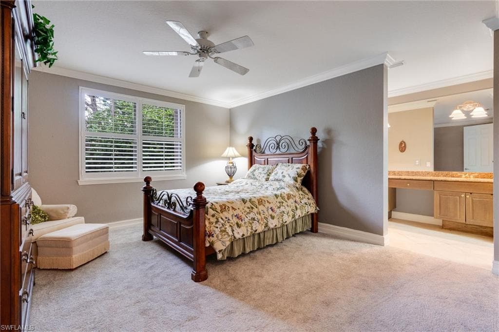 Bedroom with crown molding, ensuite bath, light colored carpet, and ceiling fan