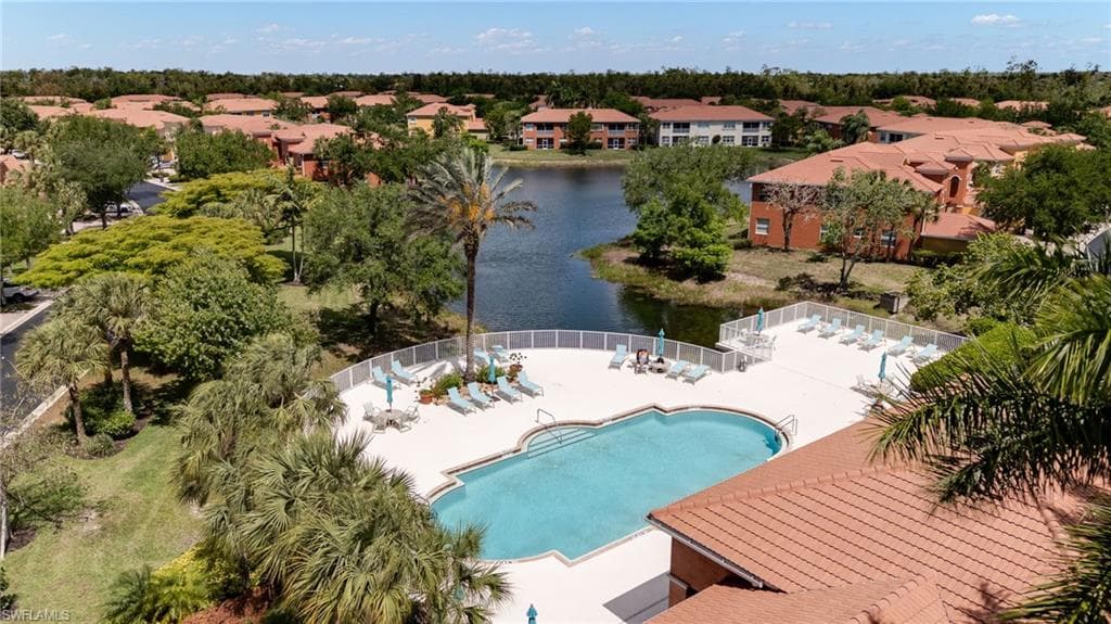 Drone / aerial view of a pool area and a nearby body of water