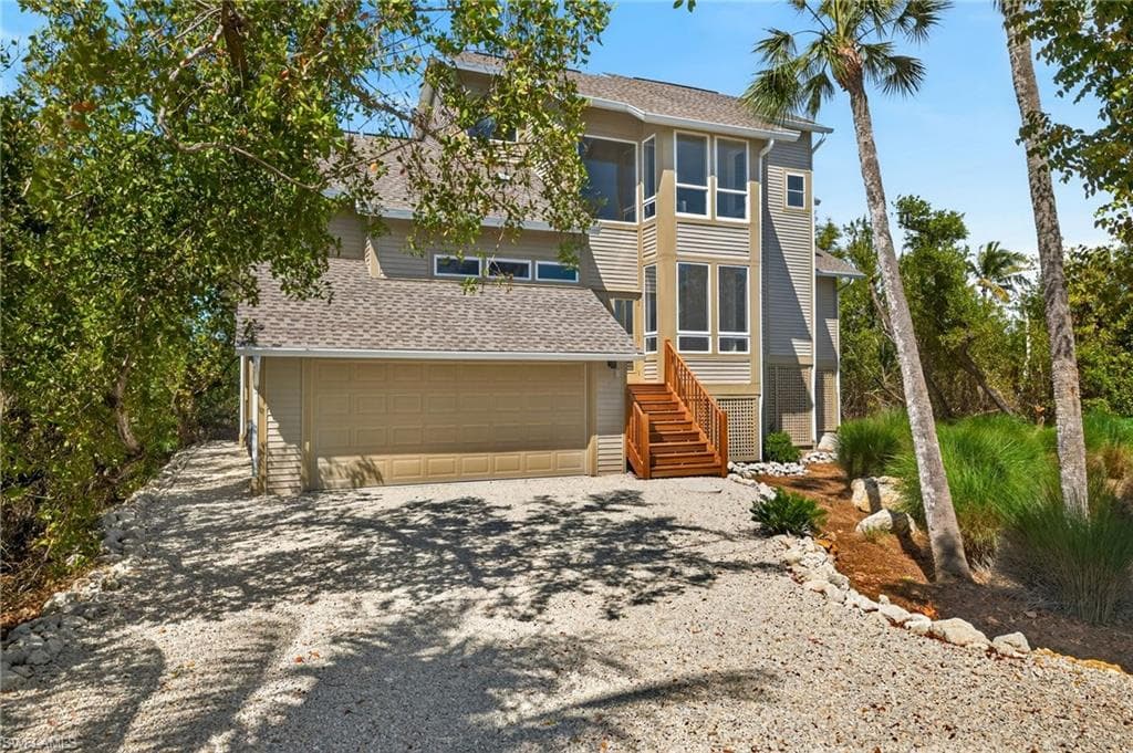 View of front of home with driveway, roof with shingles, and an attached garage