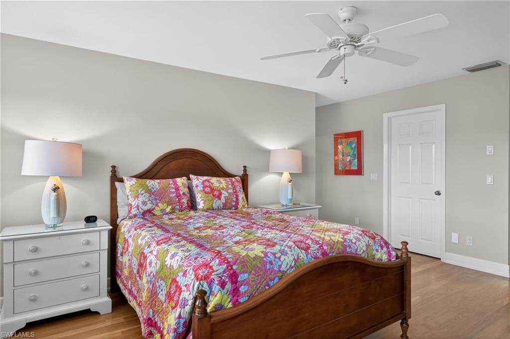 Primary Bedroom with light wood finished floors and a ceiling fan