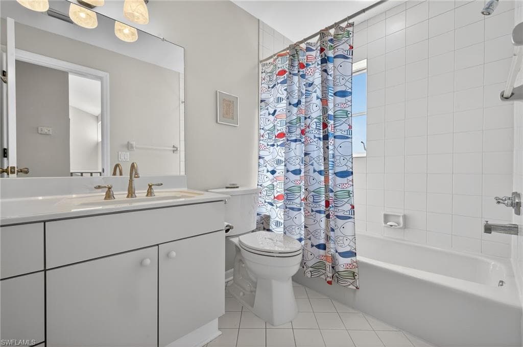 Full bathroom with vanity, light tile patterned floors, and shower / tub combo