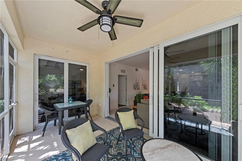 This covered patio features a ceiling fan, a textured ceiling, and a light-colored exterior wall