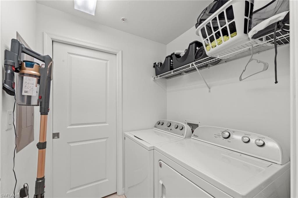 Utility room featuring a washer and dryer, a wire shelving unit, and white walls