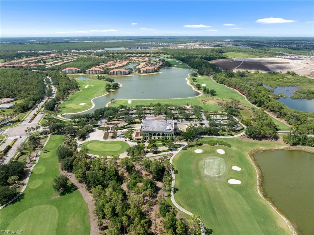 Aerial view showcasing the property's surrounding golf course, lakes, and extensive green spaces