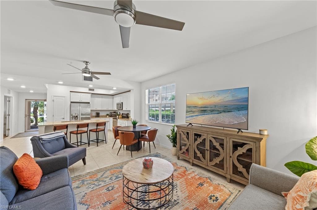 The open concept living area features recessed lighting, ceiling fans, and tiled floors