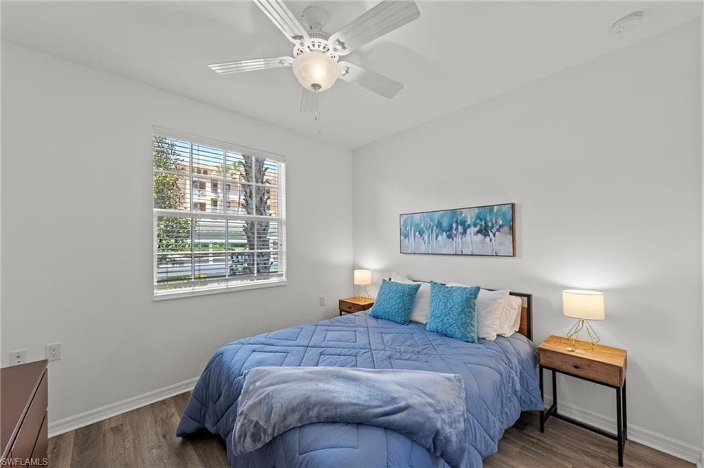 This room features a ceiling fan, a window with blinds, and wood-style flooring