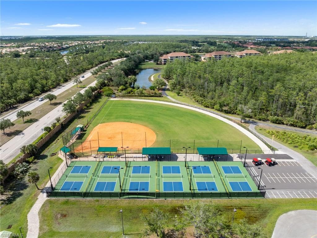 Aerial view showcasing the community amenities, including a baseball field and several pickleball courts