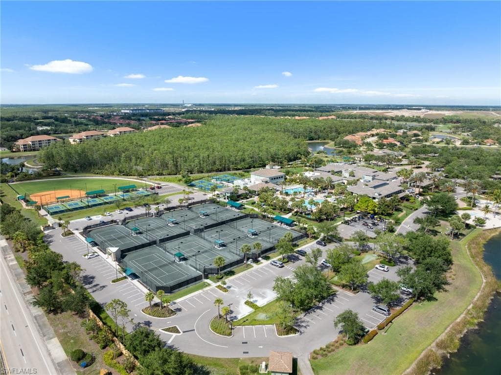 Aerial view of the community amenities, featuring tennis courts, a baseball field, and swimming pools