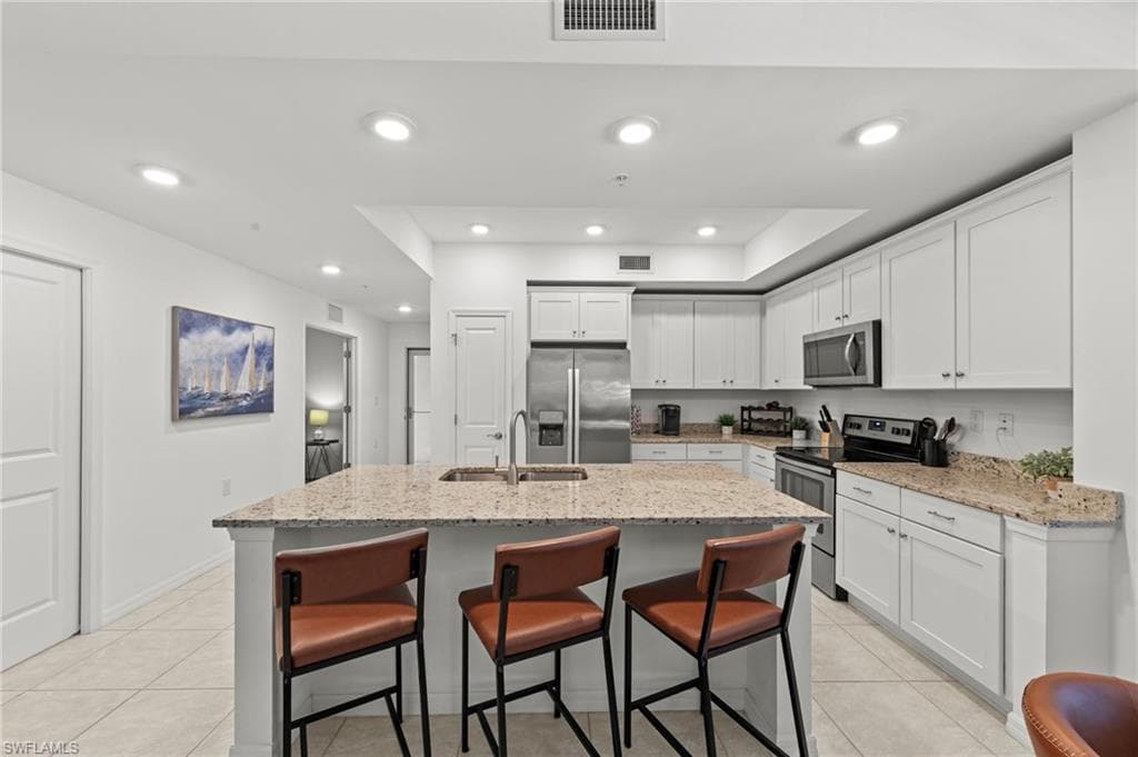 The kitchen features white cabinetry, stainless steel appliances, and granite countertops