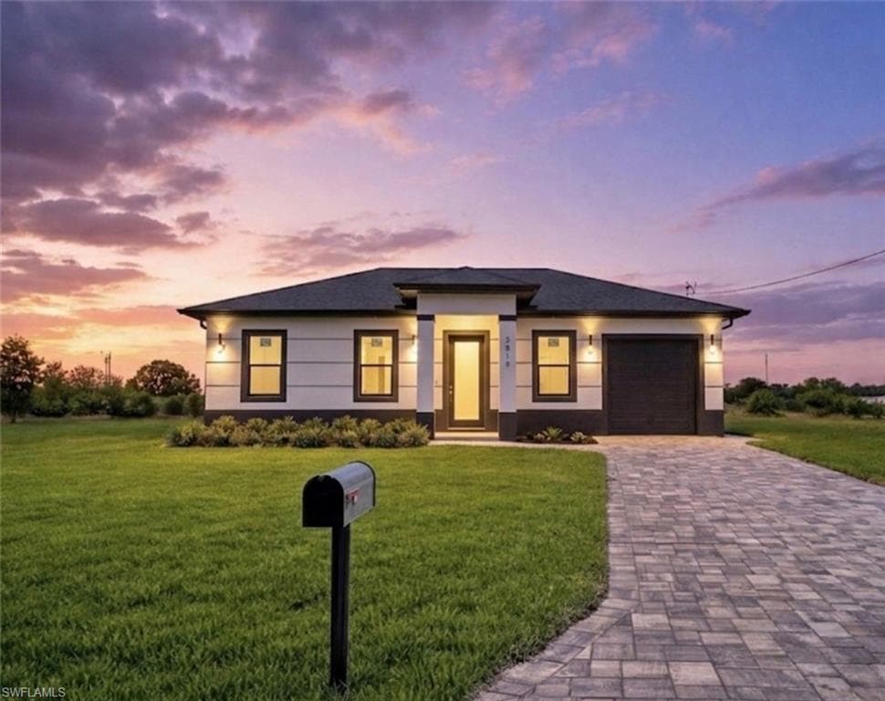 Single-story residence featuring a dark roof, light-toned siding with contrasting dark trim, and a paver driveway