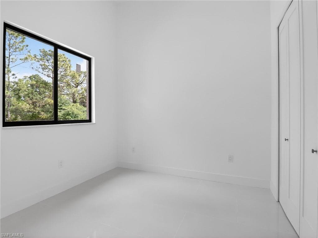 This room features a window with dark trim, offering views of surrounding trees