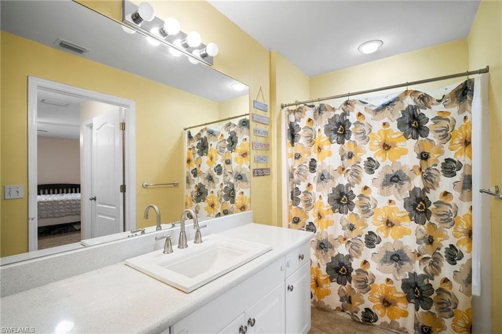 Bathroom with vanity, ensuite bath, tile patterned flooring, and a shower with curtain