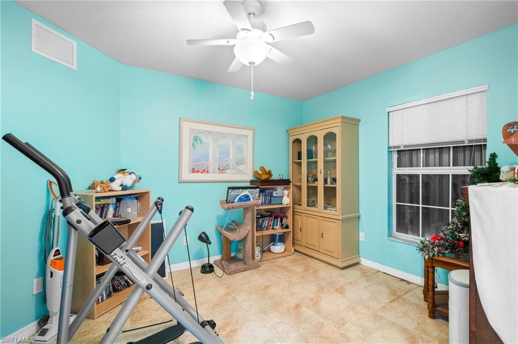 Workout room featuring a ceiling fan and baseboards