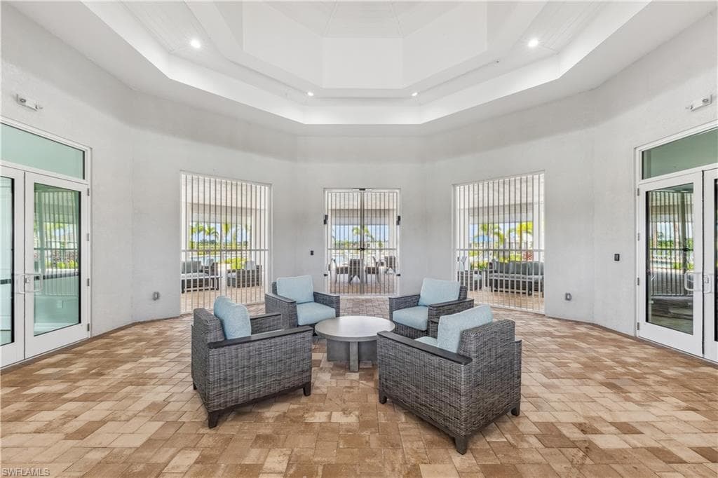 Inviting common area featuring a light-colored tile floor, recessed lighting, and multiple doors providing abundant natural light