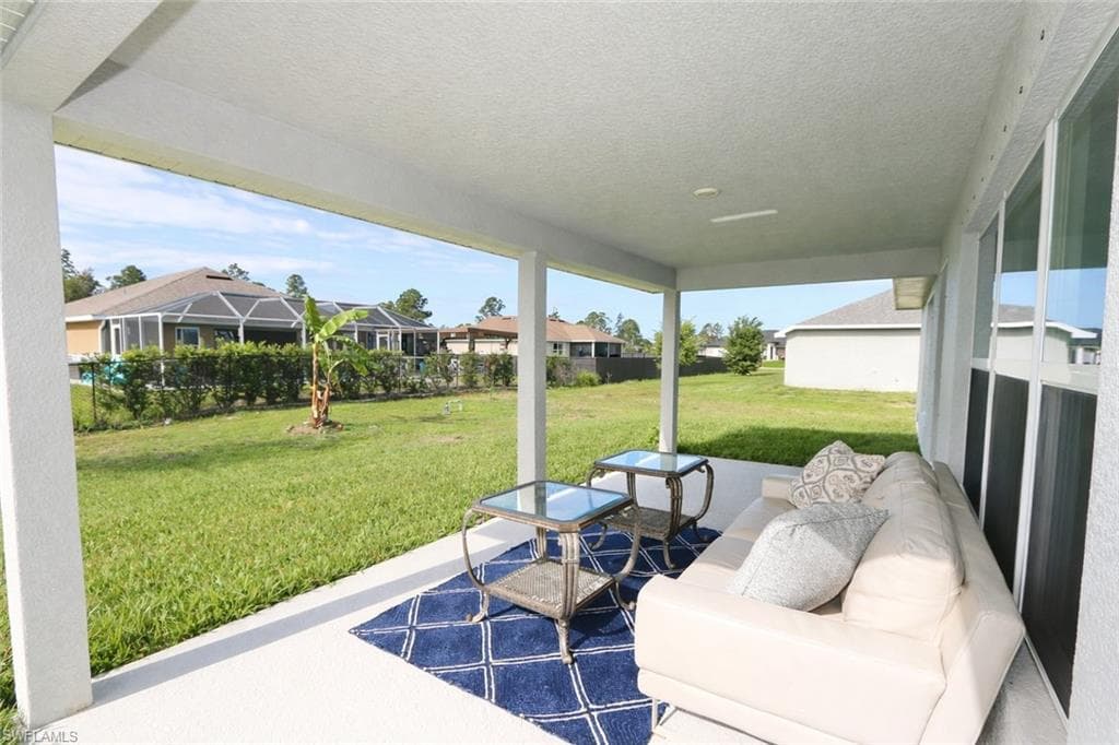 The property features a covered patio with direct access to a spacious grassy yard