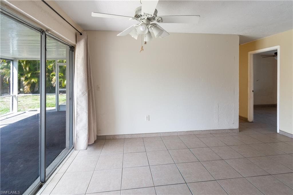 Dining area with tile flooring, a ceiling fan, and sliding glass doors leading to a screened patio
