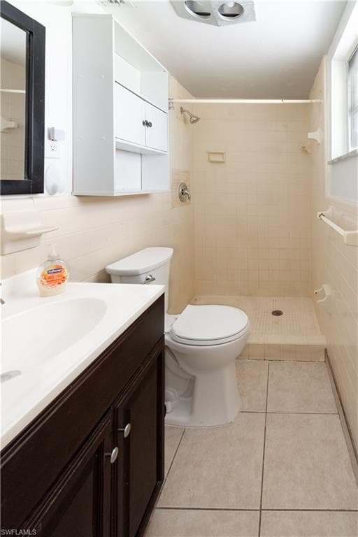 Primary Bathroom featuring a dark wood vanity with a white countertop and sink, a toilet, and a tiled shower area