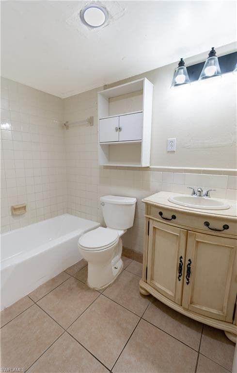 The bathroom features a tiled floor, a white bathtub, a toilet, and a vanity with a sink and storage