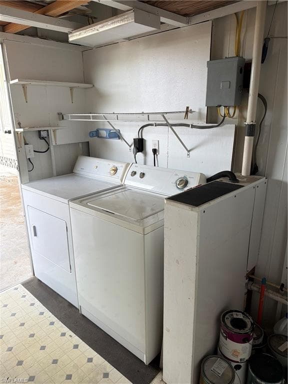 Dedicated utility area featuring a washer and dryer, practical shelving, and a patterned vinyl floor