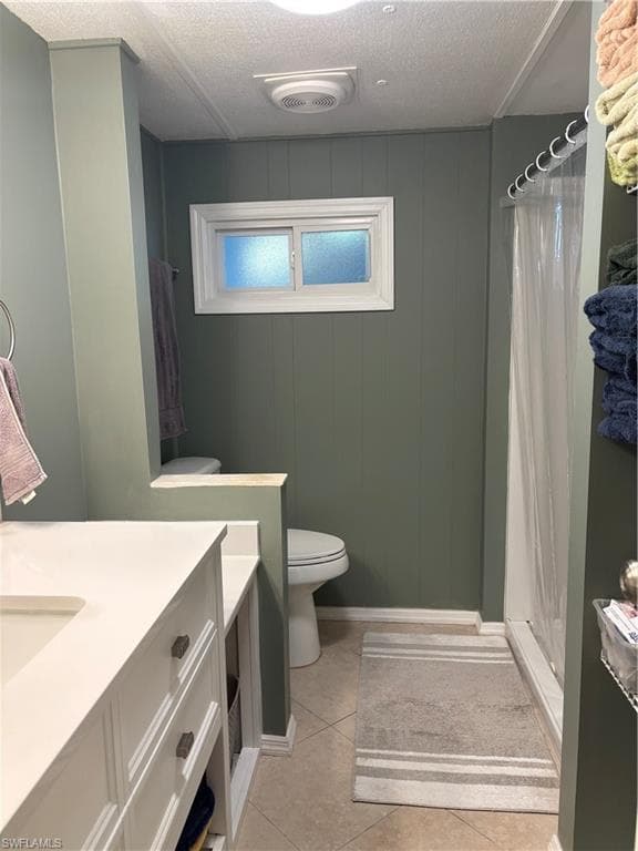 Bathroom featuring a vanity with a white countertop and sink, a toilet, a shower with a clear curtain, and a window with frosted glass