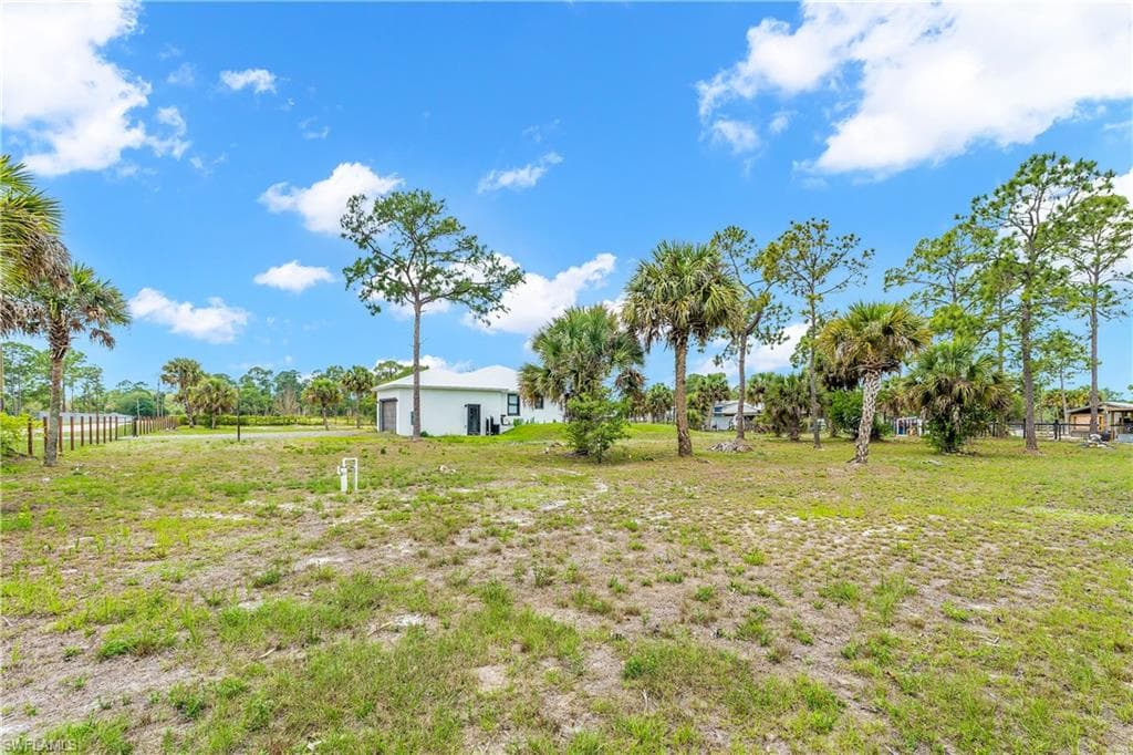Expansive undeveloped land featuring a modern white stucco exterior property with a two-car garage