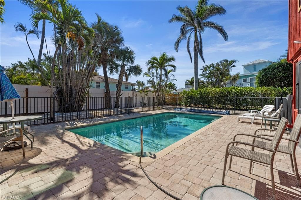 View of swimming pool with fence and a patio area - Virtually Edited Exterior Image