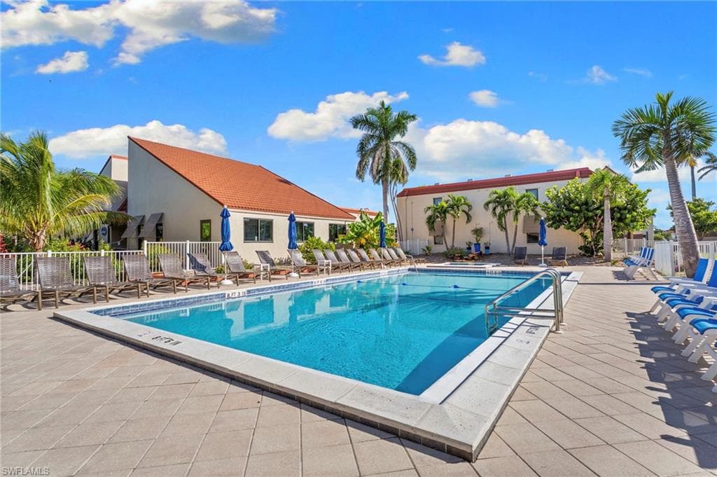 Rectangular swimming pool surrounded by a large paver deck