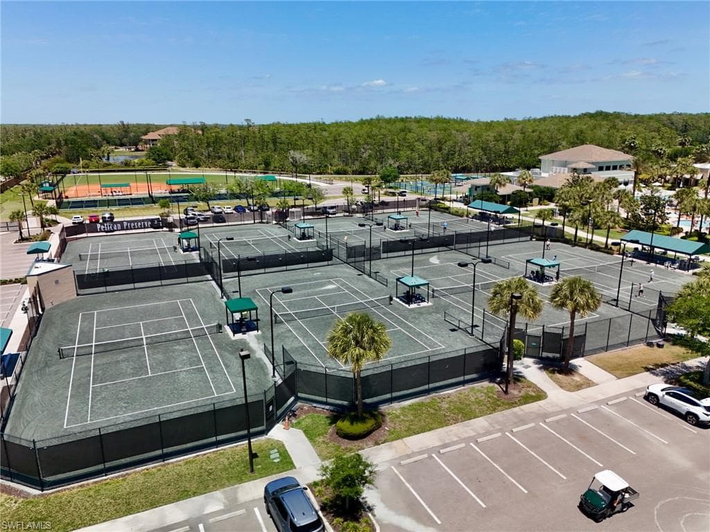 Extensive tennis facilities featuring multiple hard courts, clay courts, shaded seating areas, and perimeter fencing