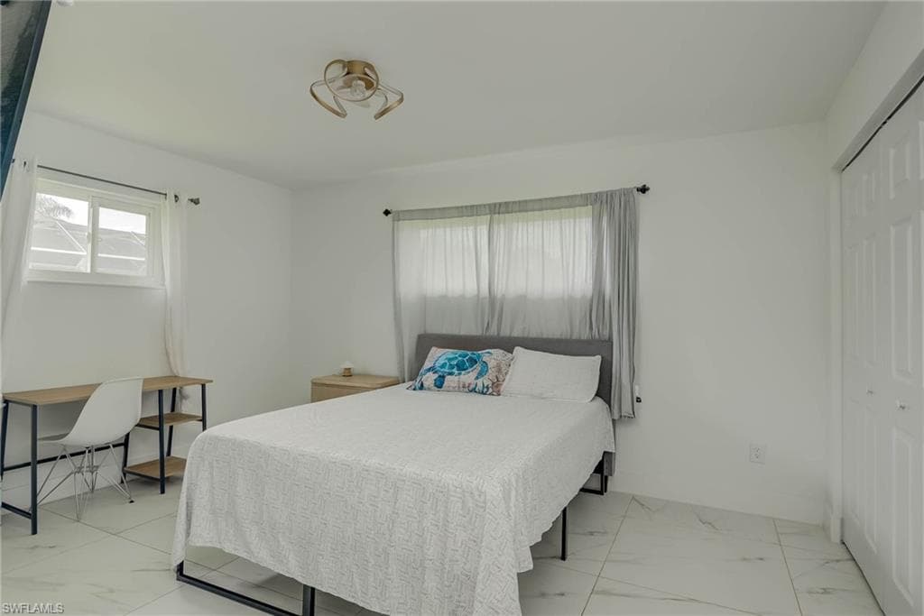 Bright interior space featuring white walls and large format tile flooring
