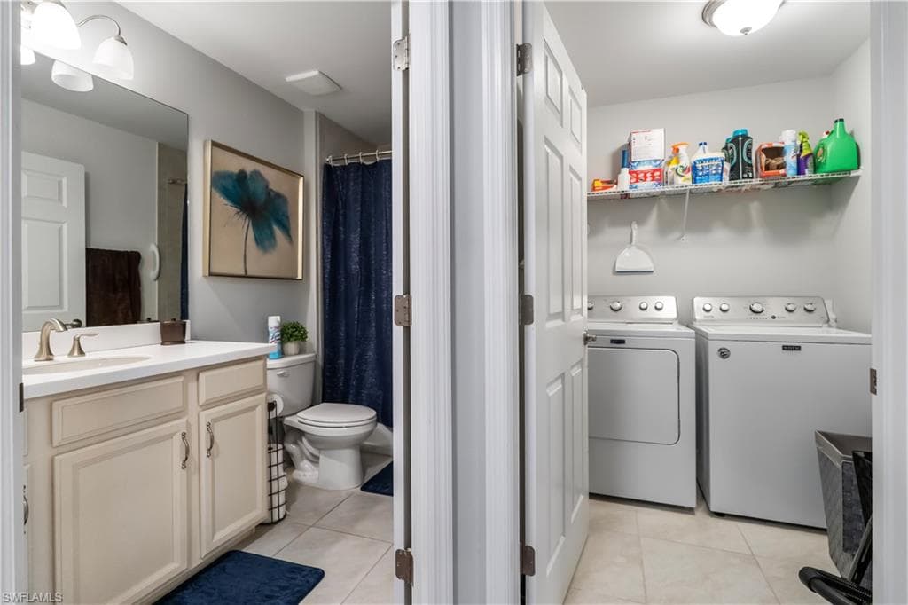 Laundry area with full-sized washer and dryer units, complemented by open wire shelving