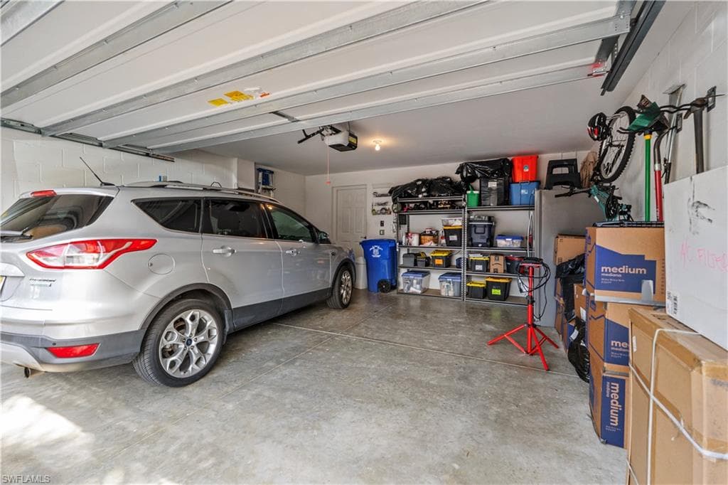 Spacious two-car garage featuring a concrete floor and white walls
