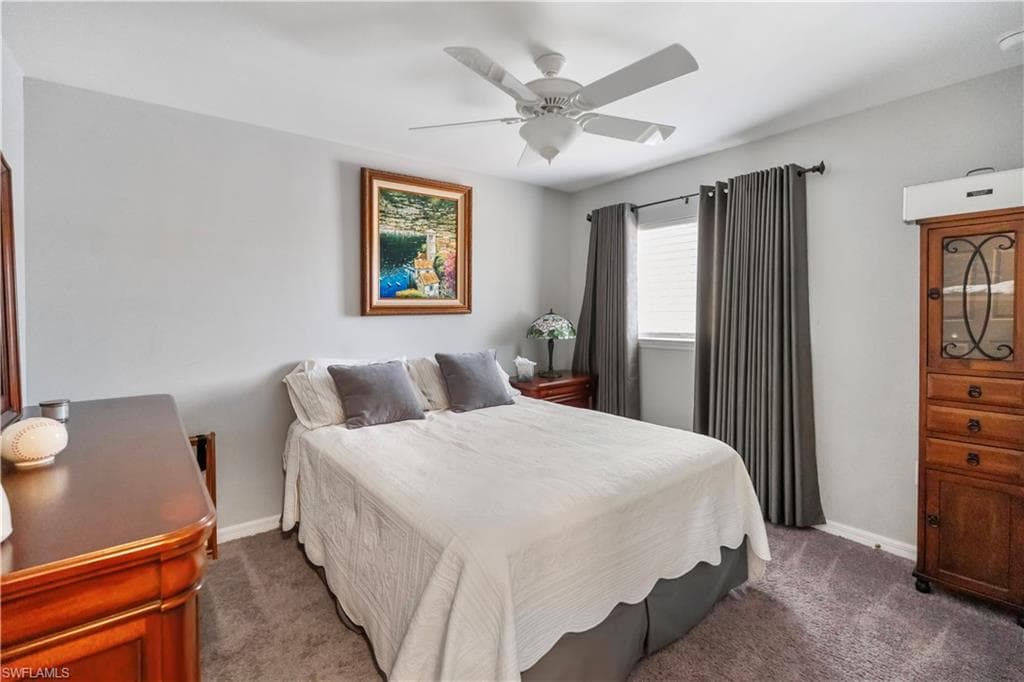 Carpeted room featuring a ceiling fan, a window with blinds, and light gray walls