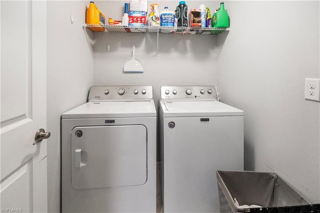 Dedicated laundry area featuring a white top-load washing machine and a white front-load dryer