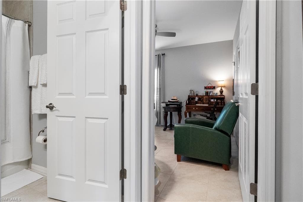 Interior space featuring light grey walls, white trim, and neutral tile flooring