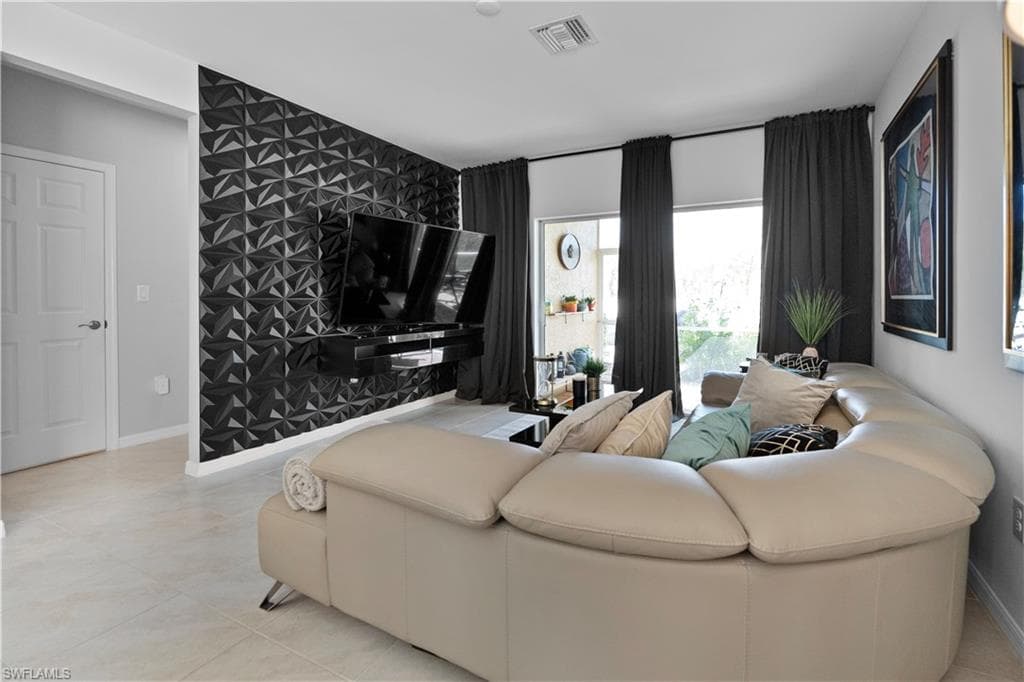 Living area featuring a striking accent wall with textured geometric panels