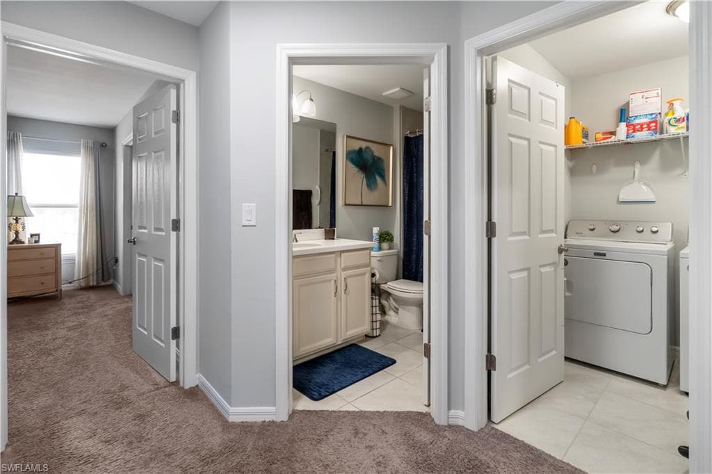Hallway featuring soft-pile carpeting, paneled doors, and light gray wall paint