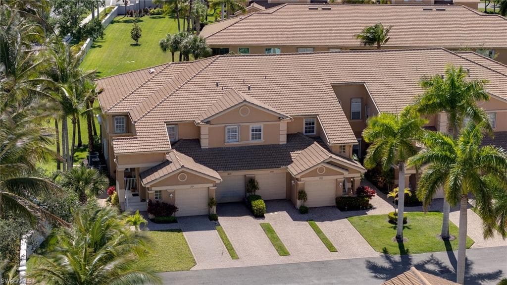 Multi-level residential structure featuring a tiled roof and stucco exterior