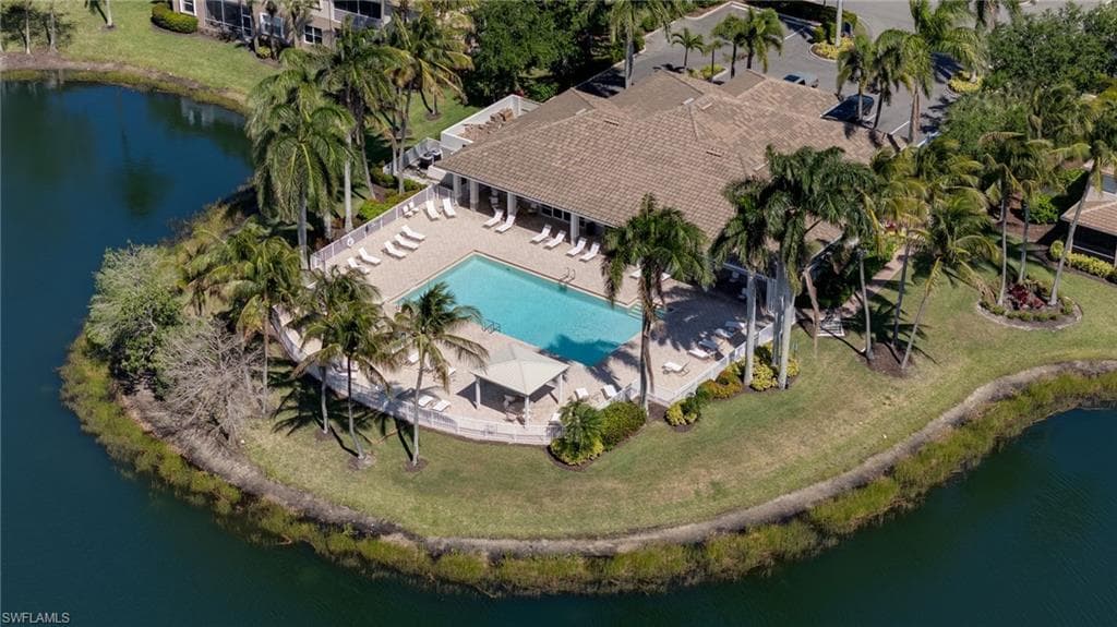 Community pool and clubhouse with expansive surrounding water features and lush tropical landscaping