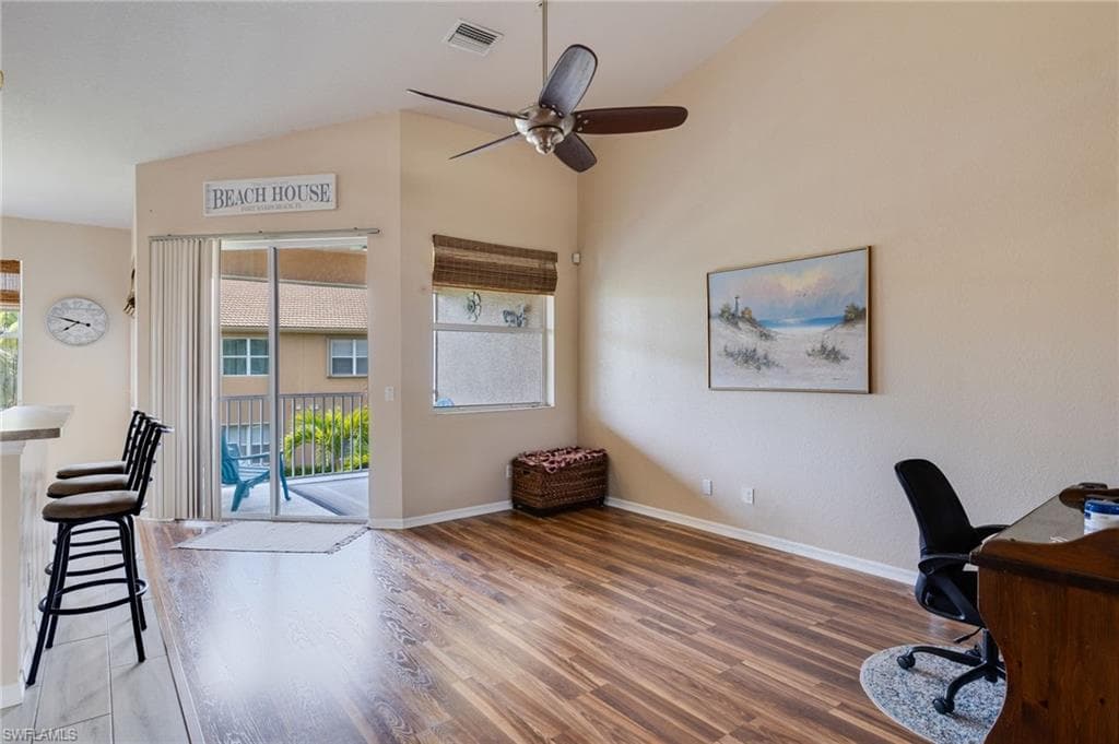 Open living area featuring vaulted ceilings and wood-finish flooring