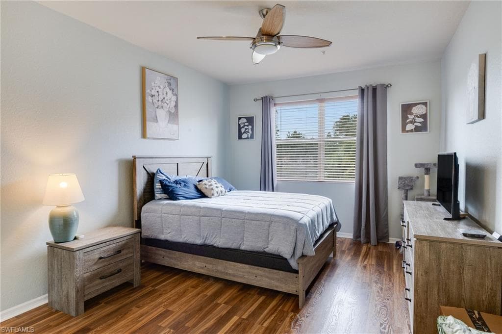 Bedroom featuring wood-finish flooring, a ceiling fan, and a window with blinds