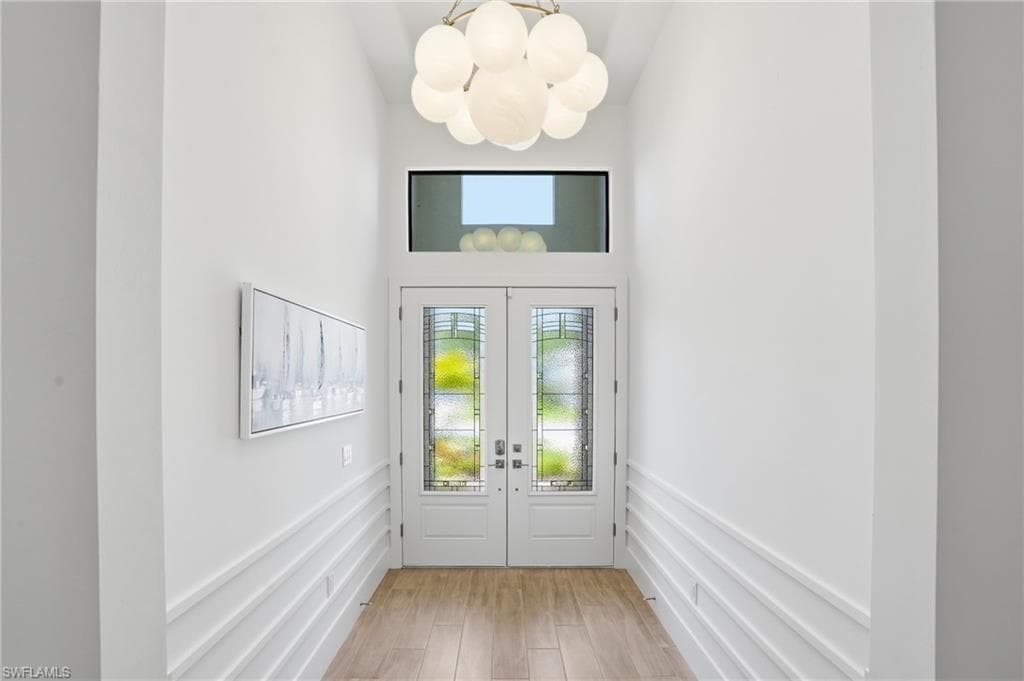 Double entry doors with decorative glass panels and transom window