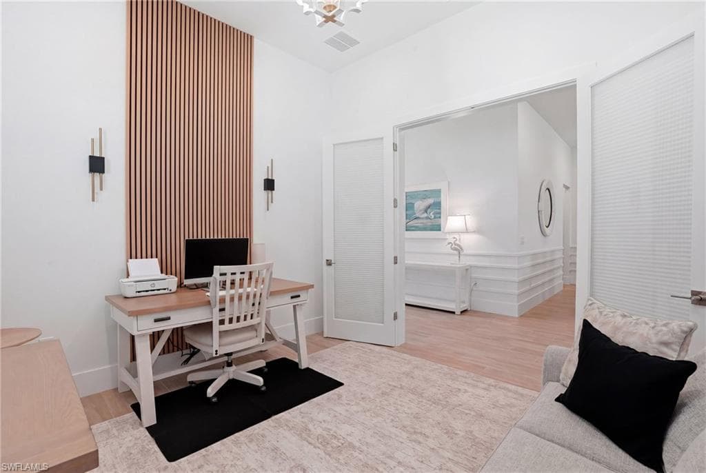 Interior space featuring a vertical wood slat accent wall with integrated sconce lighting