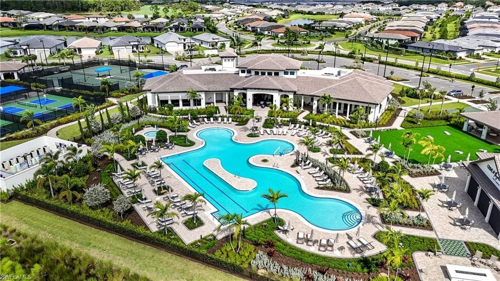 Expansive resort-style pool with multiple swim areas, surrounded by a large sun deck with numerous lounge chairs