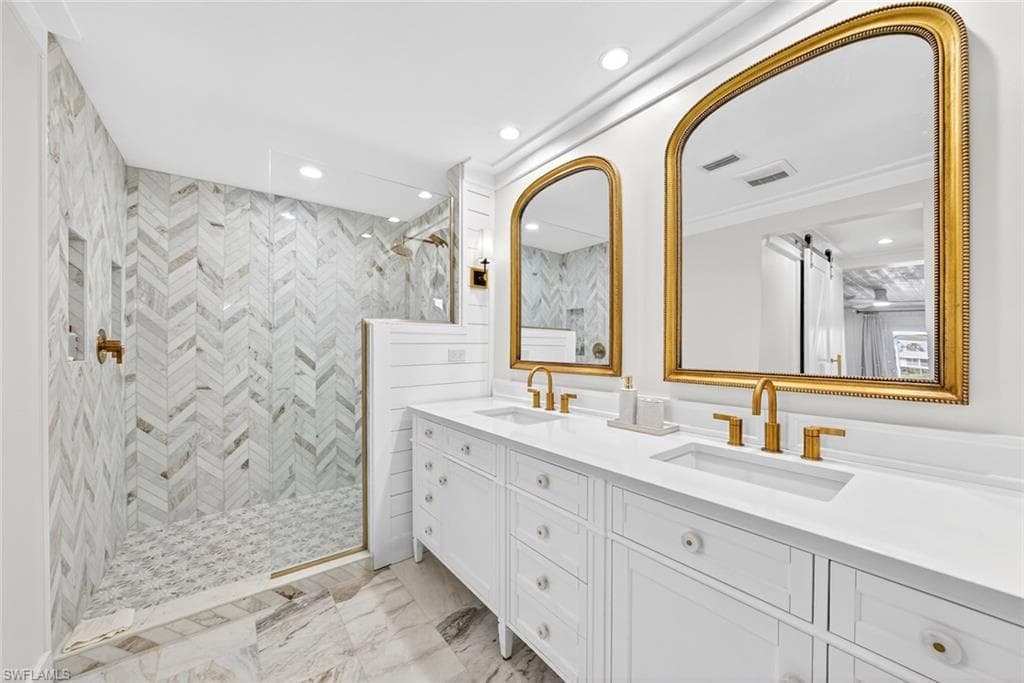 Dual vanity with white cabinetry, integrated sinks, and gold-finish fixtures